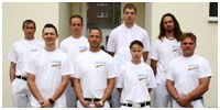 Die Fachkräfte der Fritsche Malerbetrieb GmbH stehen in weiß gekleidet vor einem Gebäude.